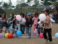 地域のみなさんが中心の玉川コミュニティまつり。子どもたちが色とりどりの風船を拾っています。