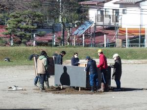 水の取り入れ口に板を取り付ける保護者と職員