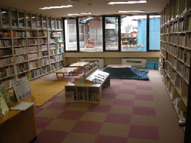 宮川地区こども館および図書館分室の室内の写真、両側の本棚には整然と蔵書が並べられ、中央の台の上には子供用の絵本が置かれている