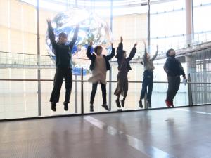 日本科学未来館の大きな地球の模型の前で跳ぶ子どもたち