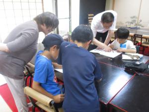 地域の方に教えてもらいながら、子どもたちが夏休みの宿題に取り組んでいます。