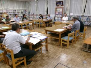 地域の方々が集まり、机を囲んで会議をしている様子