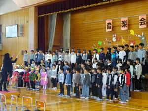 ステージで、つばさをくださいを歌う全校児童