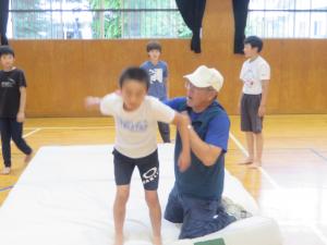 講師の方に補助をしてもらいながらマット運動に取り組む児童の様子