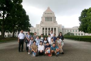 6年生が国会議事堂の前で集合写真を撮影している様子
