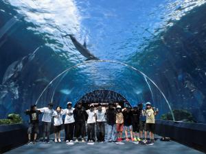 6年生が八景島シーパラダイスで集合写真を撮影している様子