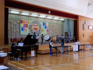 体育館のステージで音楽クラブが合奏をしている様子。