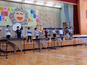 体育館のステージで1年生が鍵盤ハーモニカの演奏をしている様子。