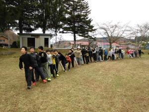 全校児童が焚火を囲んでジェンカというゲームをして交流する様子。