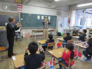 1年生の児童が田中正尋さんに手話を教えていただいている様子。