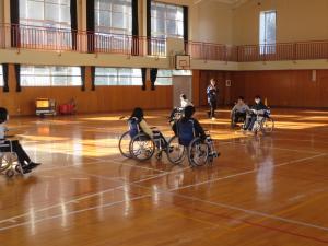 6年生の児童が車いすに乗り、車いすを動かしたり、車いすバスケットボールをやったりしている様子。
