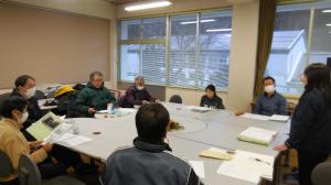 泉野小学校応援隊の皆さんと学校職員が円になって席に座り、話し合いをする様子。