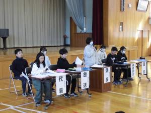 児童総会で説明する6年生