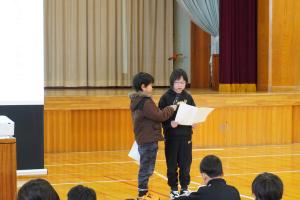 2年生と4年生の代表児童が目標を発表している様子。