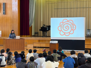校長先生がスクリーンを使って全校に話をしている様子
