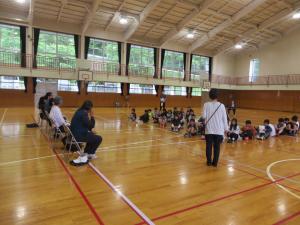 クラブ発足式で、4・5・6年生が体育館に集まり講師の皆さんに挨拶をする様子。