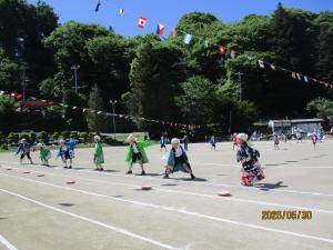 1、2、3年生の子どもたちが法被を着て、「ダイナミック琉球」の曲に合わせて踊りを踊っている様子