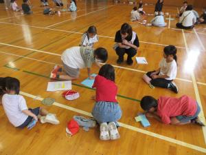 1年生から6年生が縦割り班で話し合いをしている様子