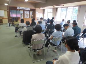 地域の方が壇上で泉野の子どもたちのよさについて話をしている様子